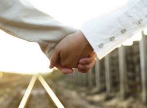 Couple Holding Hands on a Railroad Track --- Image by © Royalty-Free/Corbis
